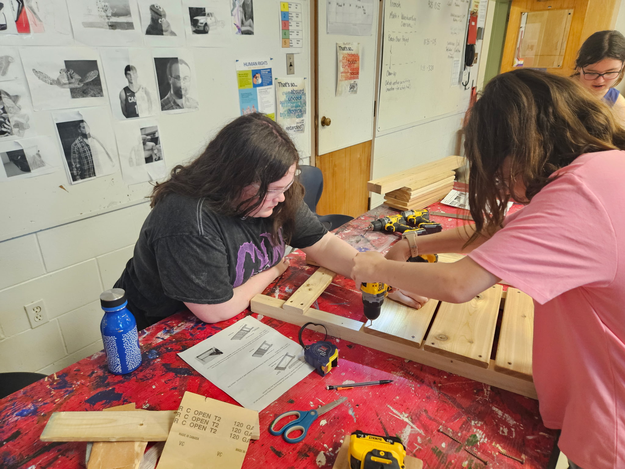 Two students in a classroom working together to build a folding chair