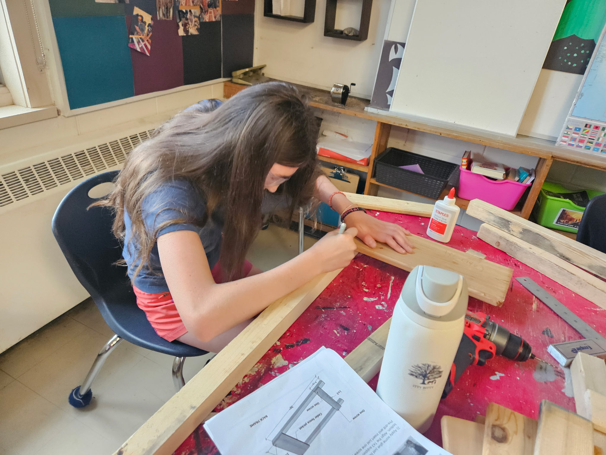 A student in a classroom building a folding chair